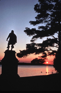 Photo of John Smith statue facing the James River at sunset.