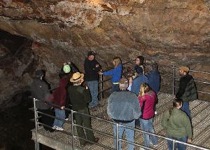 Tour group standing on metal platform in Jewel Cave. Ranger is talking with the group.