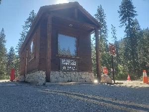 Image of the entrance booth at Lodgepole Campground, in Sequoia and Kings Canyon National Parks. One sign in the photo reads: "Lodgepole Campground. Camping by Permit Only." A second sign reads: "Campground Full. ALL Sites Reserved."