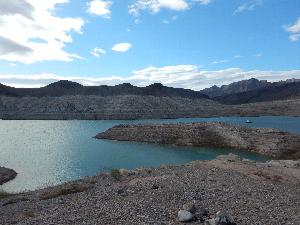 The image depicts a portion of the Echo Bay area near the location of the proposed launch ramp and access road. This image shows an overview of Lake Mead waters, eroded shorelines, and adjacent mountains. The light-colored rings on the mountain side demonstrate previous water levels.