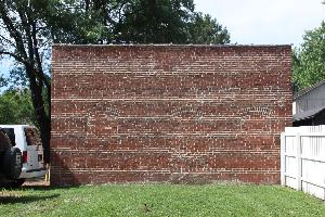 Photo of south side of Stuve Carriage House including fence line to block viewshed from Lincoln Home.