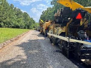 Construction equipment lined up to place new asphalt on roadway.