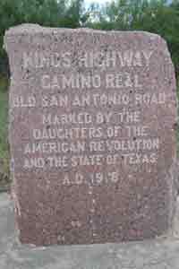 Photo of granite marker with text indicating location of historic Camino Real in Texas