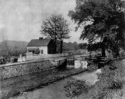 Photograph of Lock 28 taken in the late 19th Century.  The landscape at that time was open with a fence surrounding the lockhouse, unlike the wooded setting today.