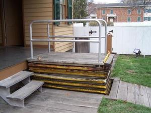 Photo of existing wheelchair lift at Lincoln Home in raised position.