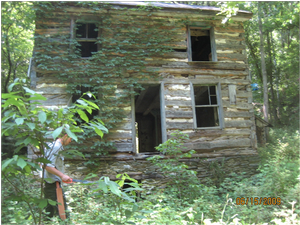 Photograph of the Staub House - two story log structure.  Picture taken to illustrate the window and door openings are unsecured.