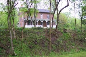 Color photograph of the red brick, two story Little House, taken from the park towpath in 2009.  Little house is located across the canal prism from the towpath.