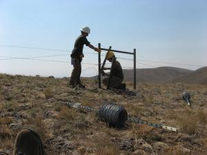 A Utah Conservation Corps crew works to rebuild a remote section of boundary fence using a wildlife friendly design.