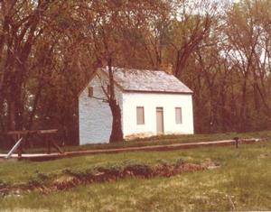 Historic photograph taken circa 1960 showing Lock 22 and the lockhouse with a pedestrian bridge across the lock