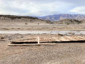 Photo of destroyed section of Salt Creek Boardwalk adjacent to Salt Creek in Death Valley.