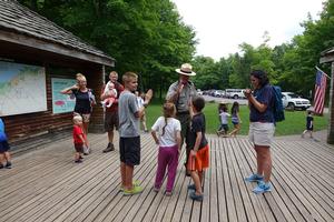 Image of an NPS staff providing information to children.