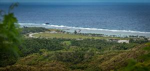 Photo looking downhill toward a grassy area and the shoreline.