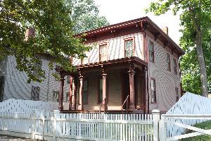 Image of front of red/brown painted house.
