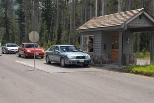 This photo depicts vehicles waiting in line to purchase an entrance pass at the south entrance of Crater Lake National Park.