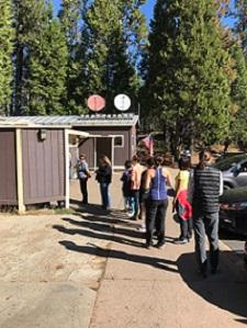 Photo of a typical day at the Big Oak Flat Visitor Contact Station; visitors experience waiting in a significant line at the restroom.