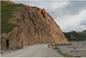 Photo looks east across Toklat Bridge to the Toklat Bluffs area where scaling will occur. Scaling will begin at the corner/bend in the road and continue east for approximately 600 feet.