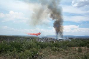 Photograph of an air tanker dropping retardant on the 2002 Long Mesa Fire in Mesa Verde National Park