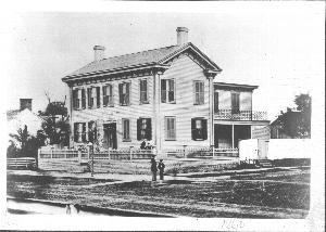 Photo of the Lincoln Home with small elm tree in brick plaza area, 1860