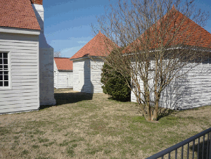 Photo of the existing outbuildings at City Point including the kitchen-laundry building (left), the "old smokehouse" (furthest right structure), " new smokehouse" (middle structure on the right), and  " dairy" (closest structure on the right).